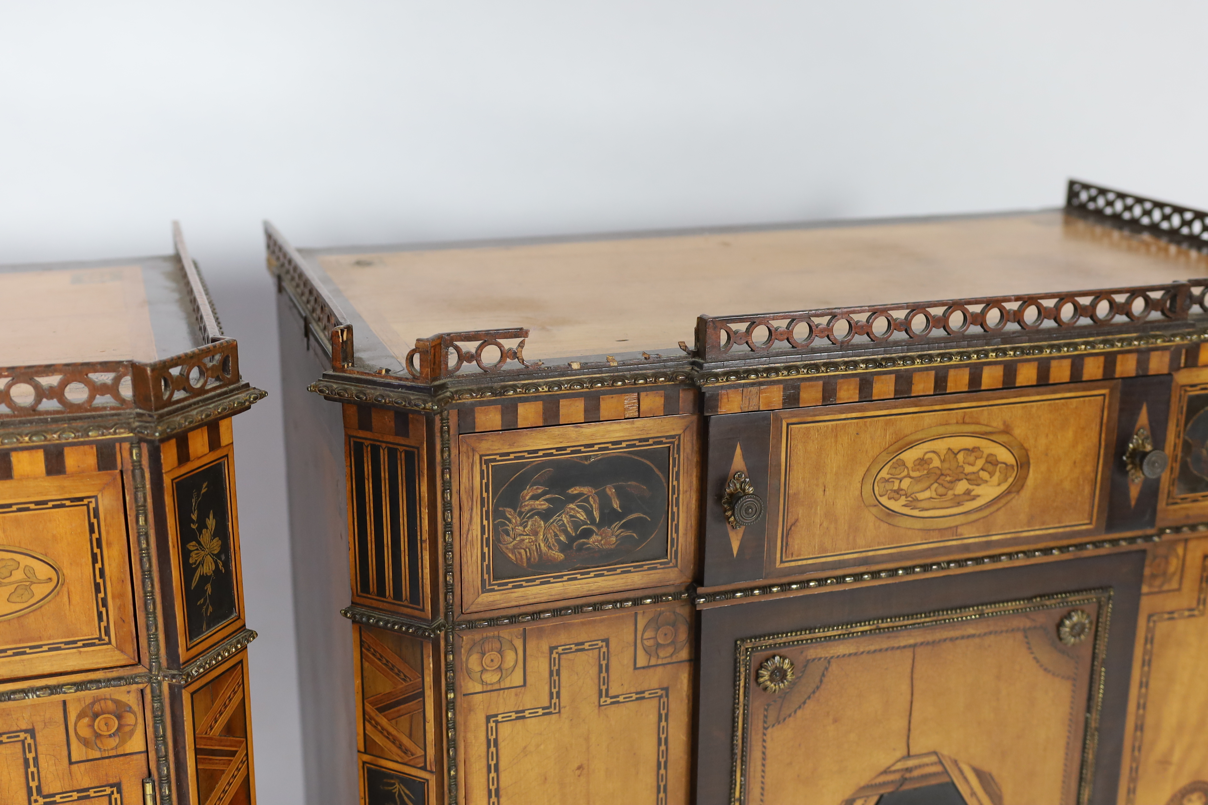 A pair of French Transitional style satinwood and marquetry side cabinets, 57cm wide, 40cm deep, 87cm high